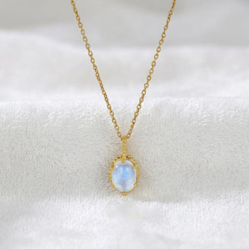Moonstone_necklace_with_oval_moonstone_in_gold_plated_silver_front_angled_view_on_soft_white_fabric_background