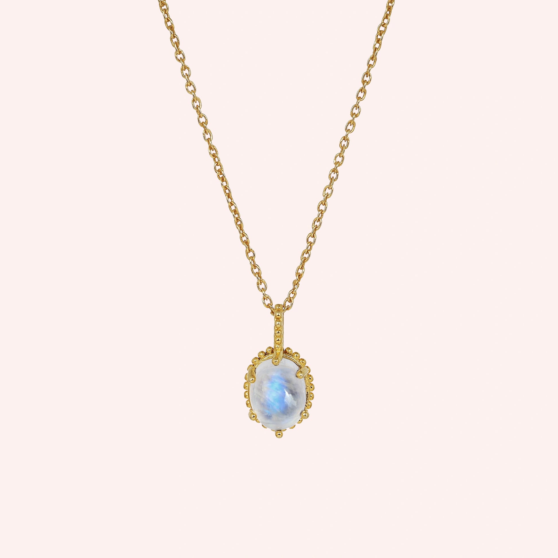 Moonstone_necklace_in_gold_plated_silver_and_glowing_moonstone_in_front_angled_view_on_solid_pink_background