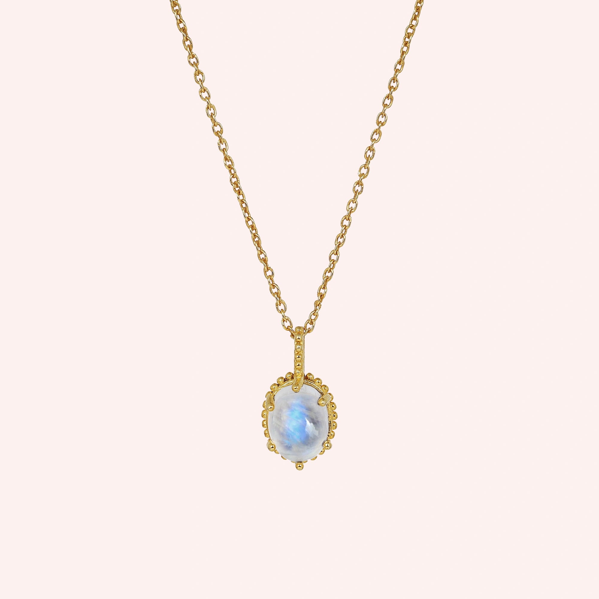 Moonstone_necklace_in_gold_plated_silver_and_glowing_moonstone_in_front_angled_view_on_solid_pink_background