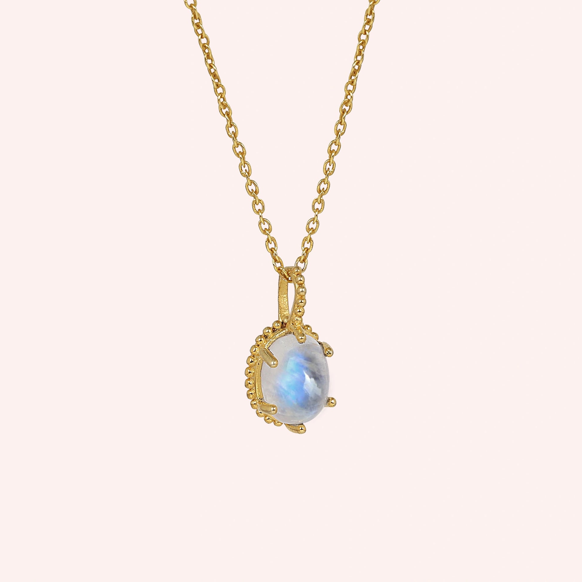 Moonstone_necklace_in_gold_plated_silver_and_glowing_moonstone_in_slightly_angled_view_on_solid_pink_background