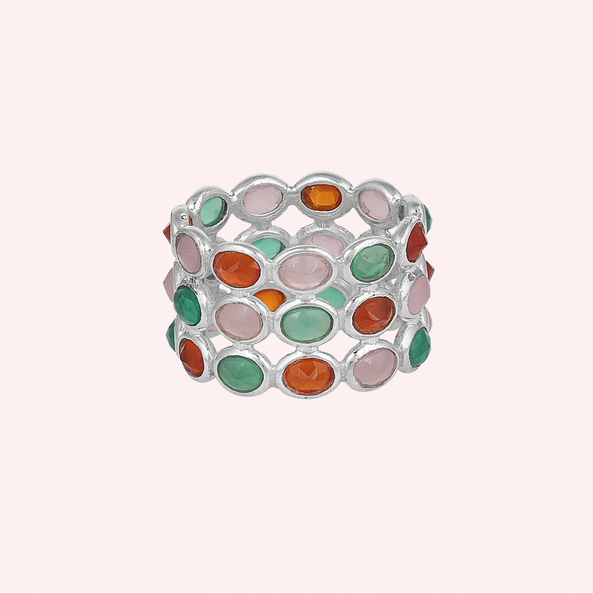 Three-row silver multi stone ring with pink green and orange oval gems on a simple pink backdrop.