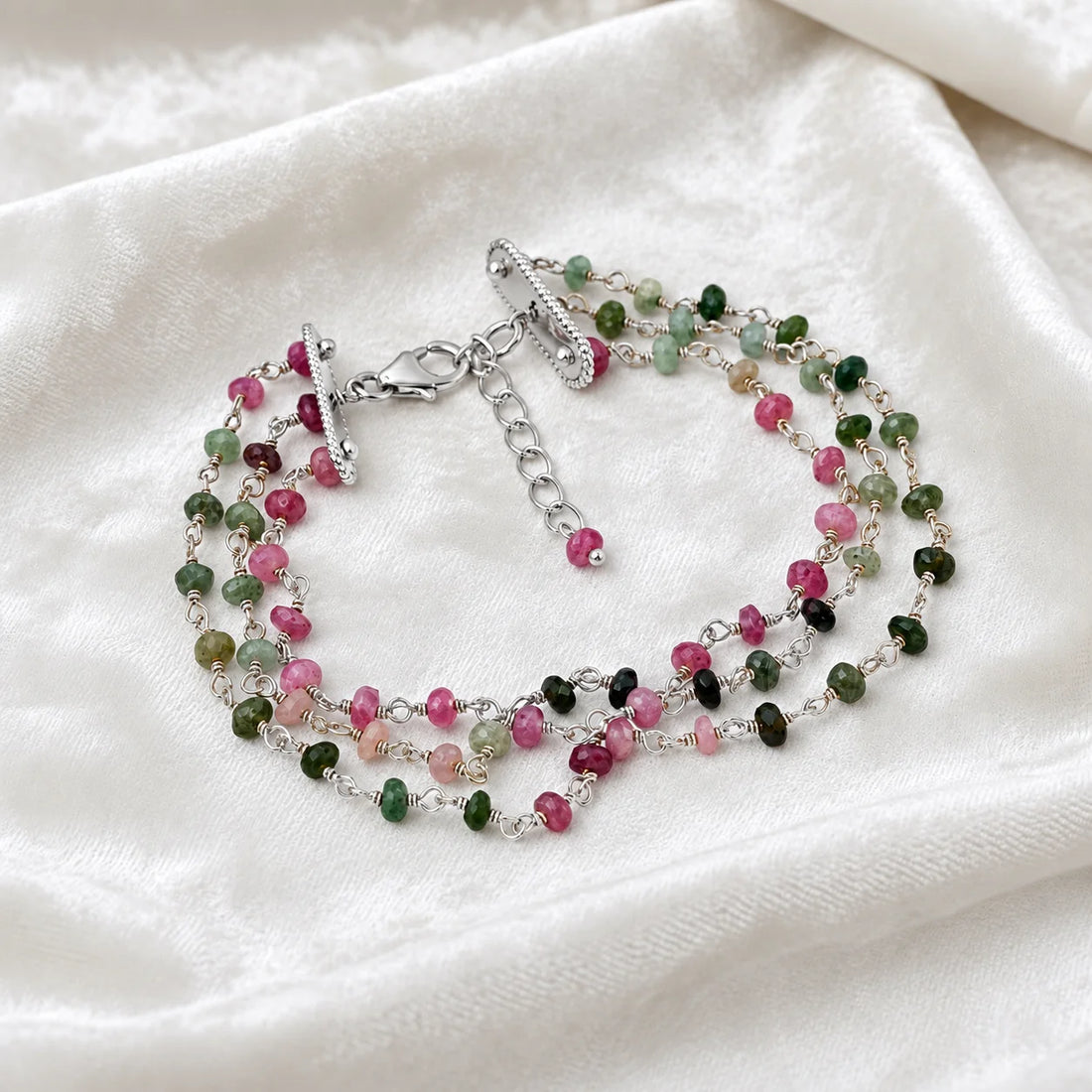 Tourmaline_bracelet_in_sterling_silver_bracelet_with_multi_tourmaline_stones_in_front_angle_on_a_white_fabric_background