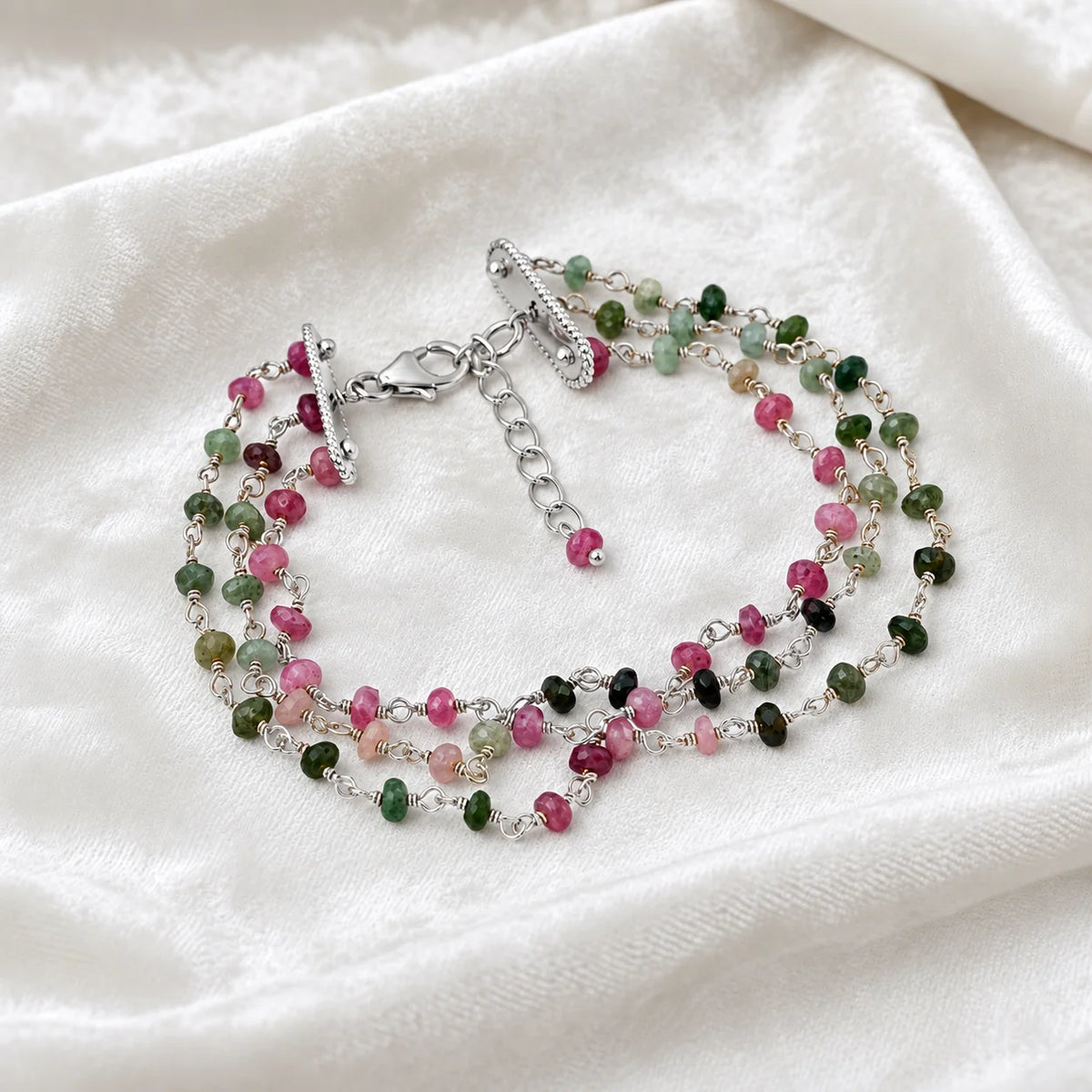 Tourmaline_bracelet_in_sterling_silver_bracelet_with_multi_tourmaline_stones_in_front_angle_on_a_white_fabric_background
