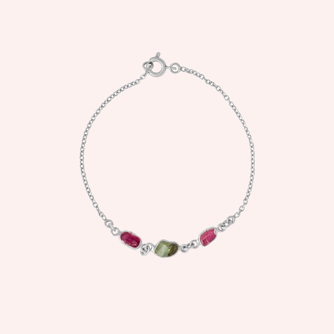 Multi_tourmaline_bracelet_in_gold_plated_silver_with_pink_and_green_tourmaline_at_front_angle_view_on_solid_pink_backgrou