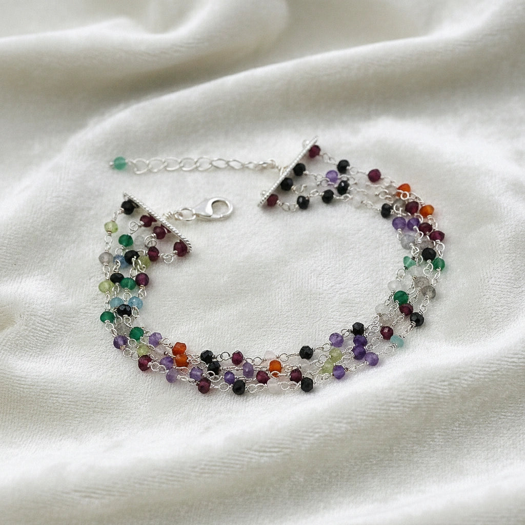 Tourmaline_bracelet_in_sterling_silver_bracelet_with_multi_tourmaline_stones_in_front_angle_on_a_white_fabric_background