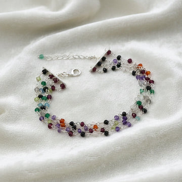 Tourmaline_bracelet_in_sterling_silver_bracelet_with_multi_tourmaline_stones_in_front_angle_on_a_white_fabric_background