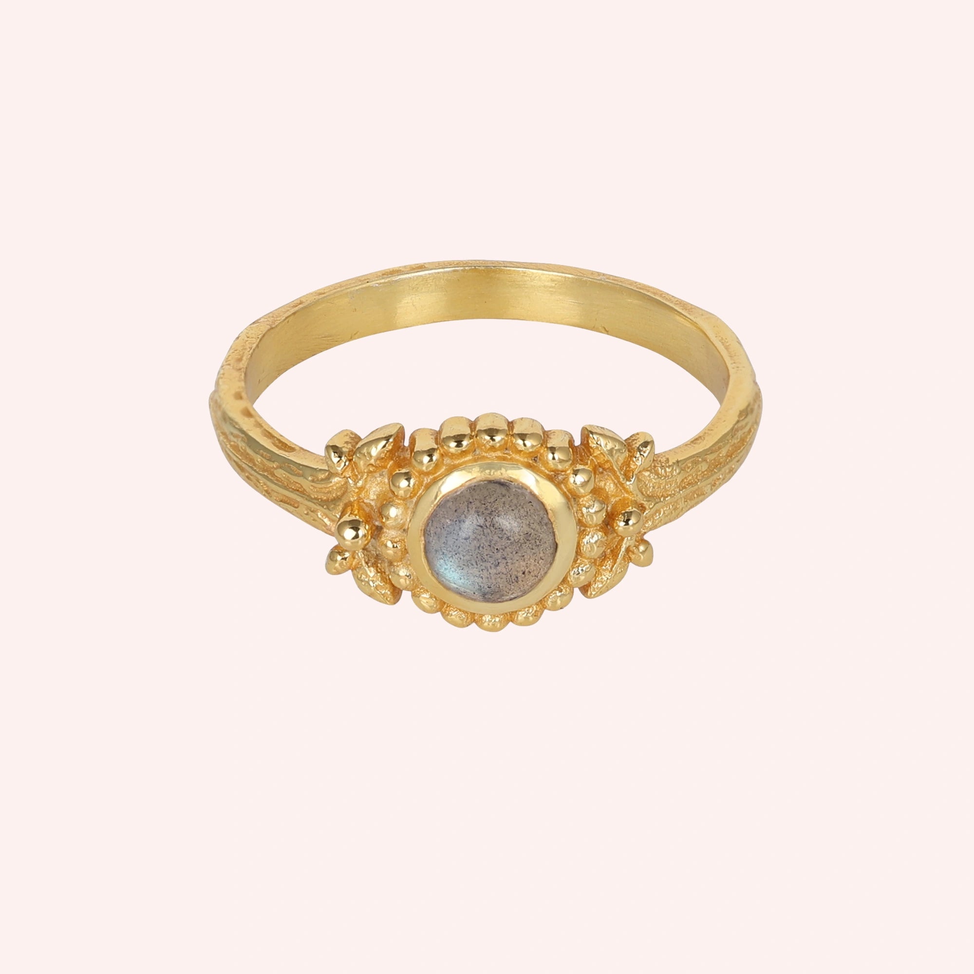 Natural_stone_ring_gold_plated_silver_with_round_labradorite_and_detailed_band_front_angle_view_on_solid_pink_background