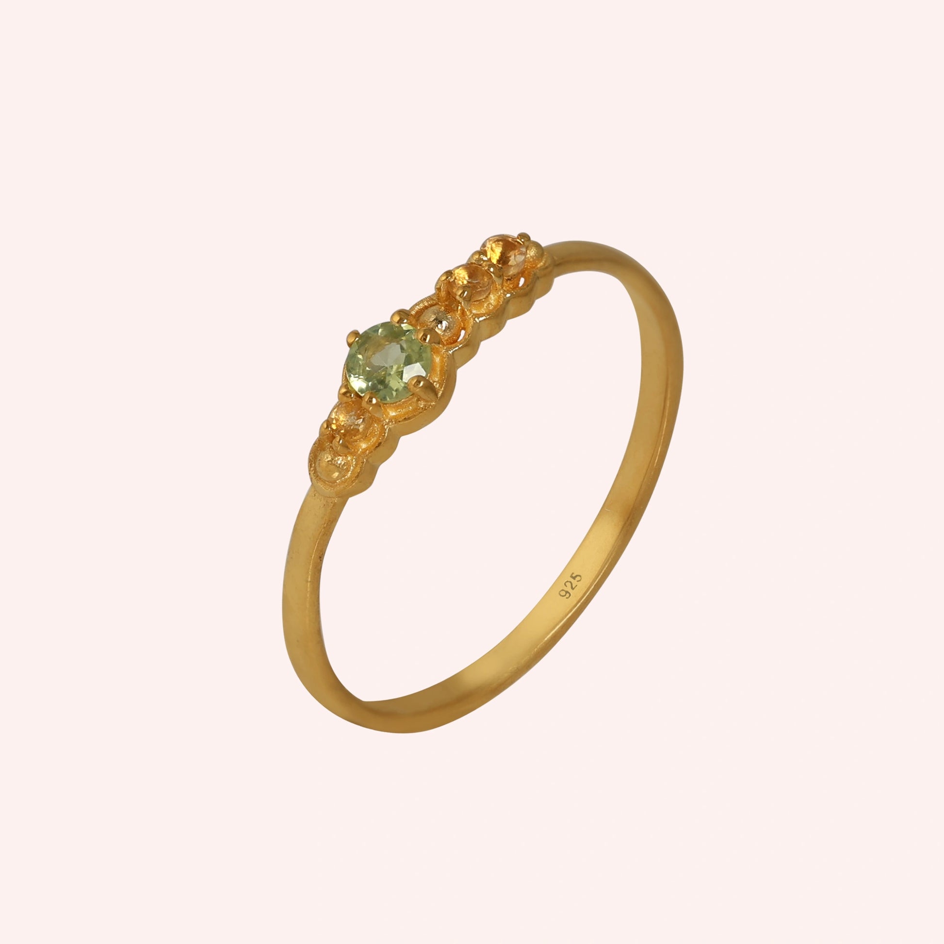 Peridot-ring-with-peridot-and-citrine-gemstones-gold-plated-silver-angled-view-on-soft-pink-background