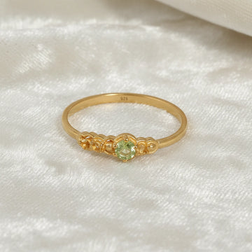 Peridot-ring-with-peridot-and-citrine-gemstones-gold-plated-silver-front-view-on-satin-background