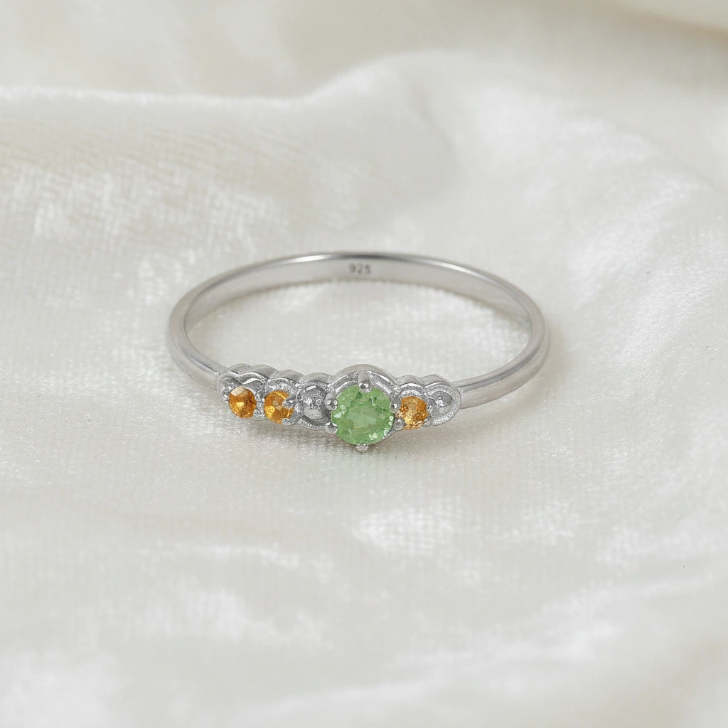 Peridot-ring-with-peridot-and-citrine-gemstones-sterling-silver-front-view-on-satin-background