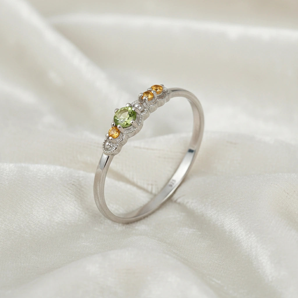 Peridot-ring-with-peridot-and-citrine-gemstones-sterling-silver-angled-view-on-satin-background