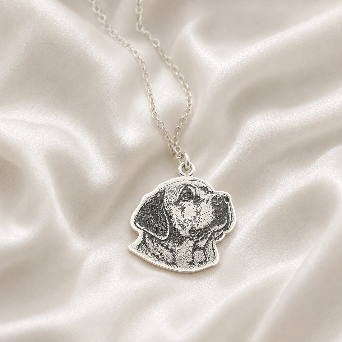 Pet_necklace_with_customized_engraved_dog_in_sterling_silver_at_front_angle_on_a_soft_fabric_background