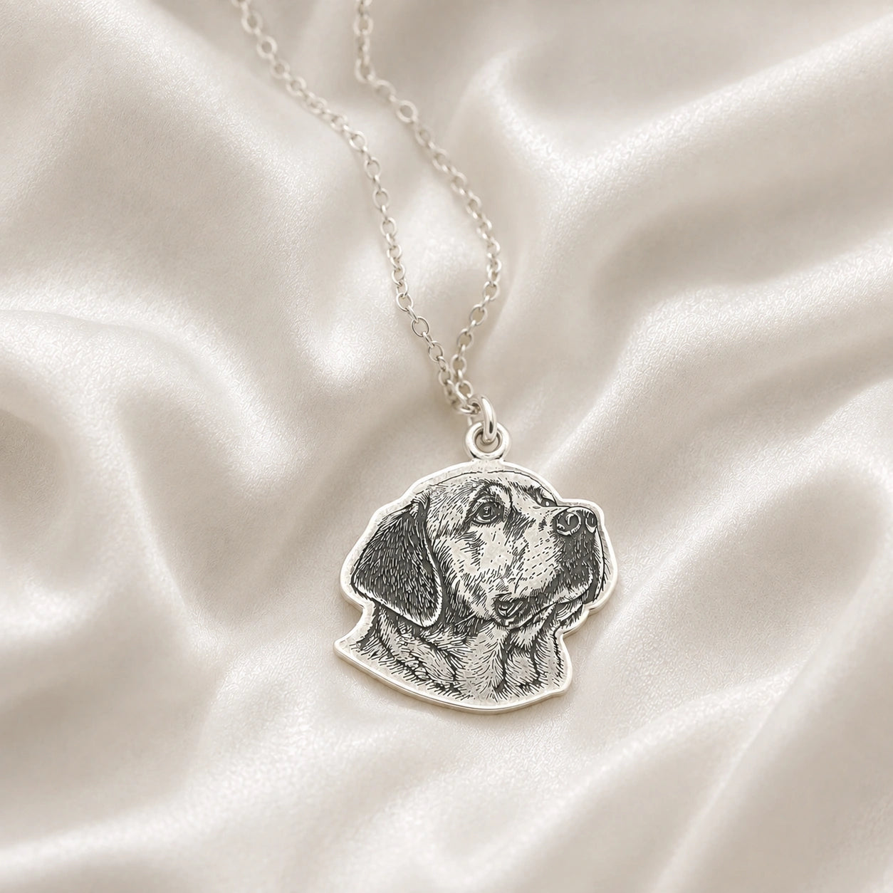 Pet_necklace_with_customized_engraved_dog_in_sterling_silver_at_front_angle_on_a_soft_fabric_background
