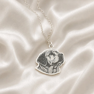 Pet_necklace_with_customized_engraved_dog_in_sterling_silver_at_front_angle_on_a_soft_fabric_background