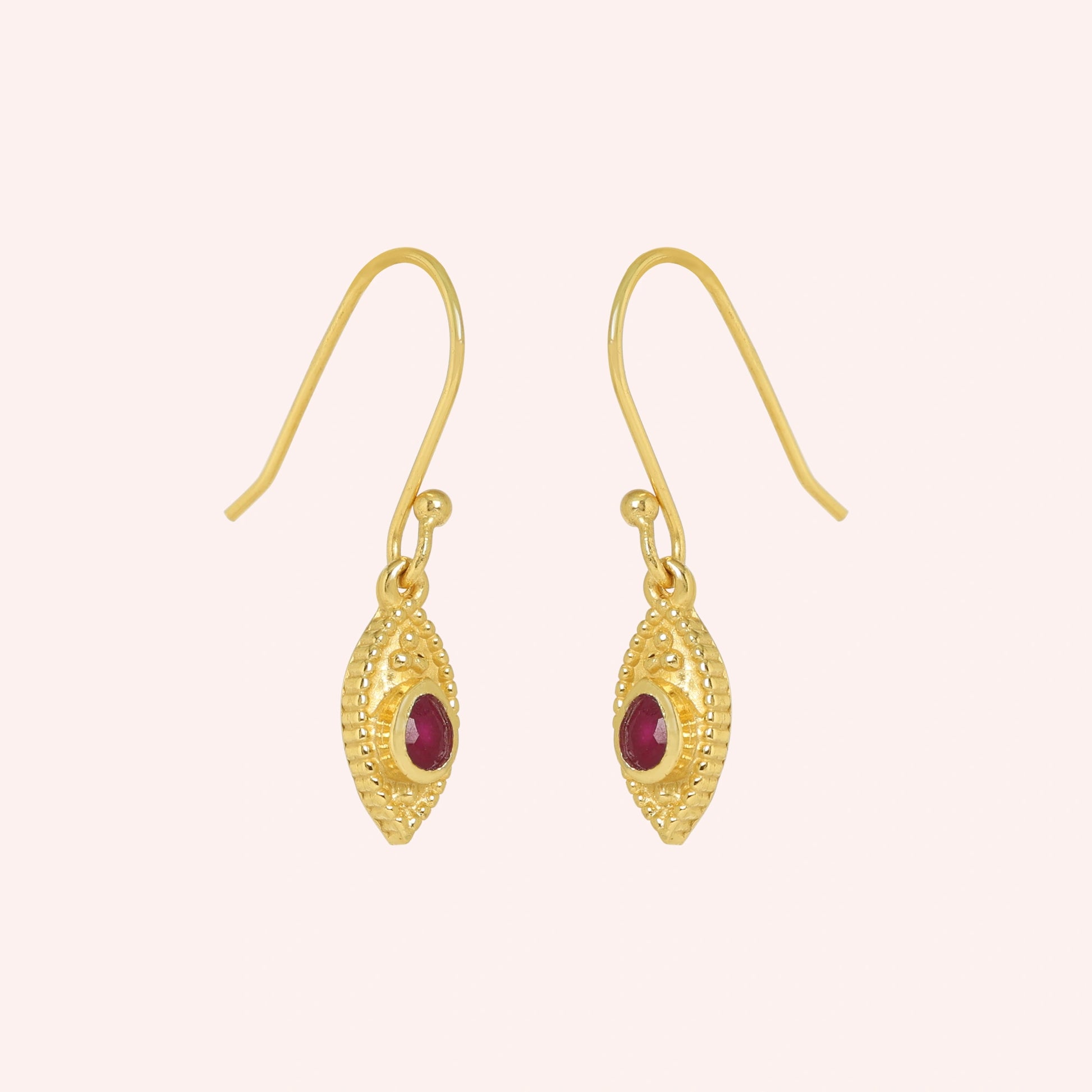 Pink_earrings_in_gold_plated_silver_with_pear_ruby_stones_at_slight_angle_view_on_solid_pink_background