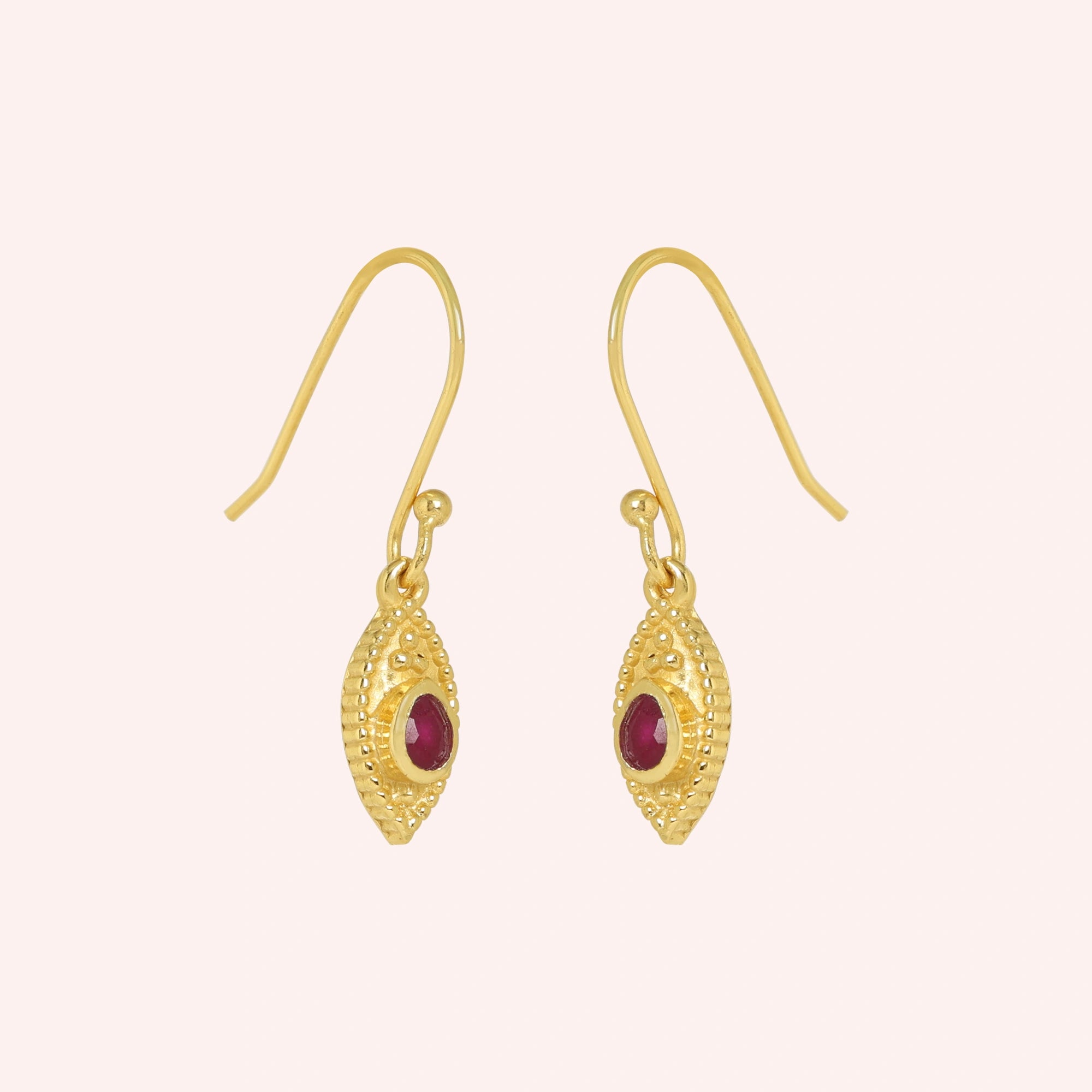 Pink_earrings_in_gold_plated_silver_with_pear_ruby_stones_at_slight_angle_view_on_solid_pink_background