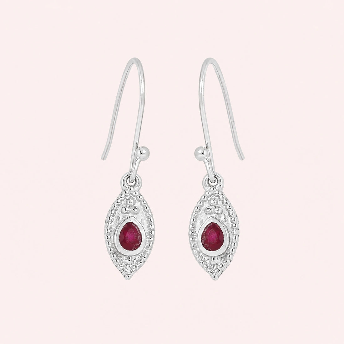 Pink_earrings_in_gold_plated_silver_with_pear_ruby_stones_at_front_angle_view_on_solid_pink_background