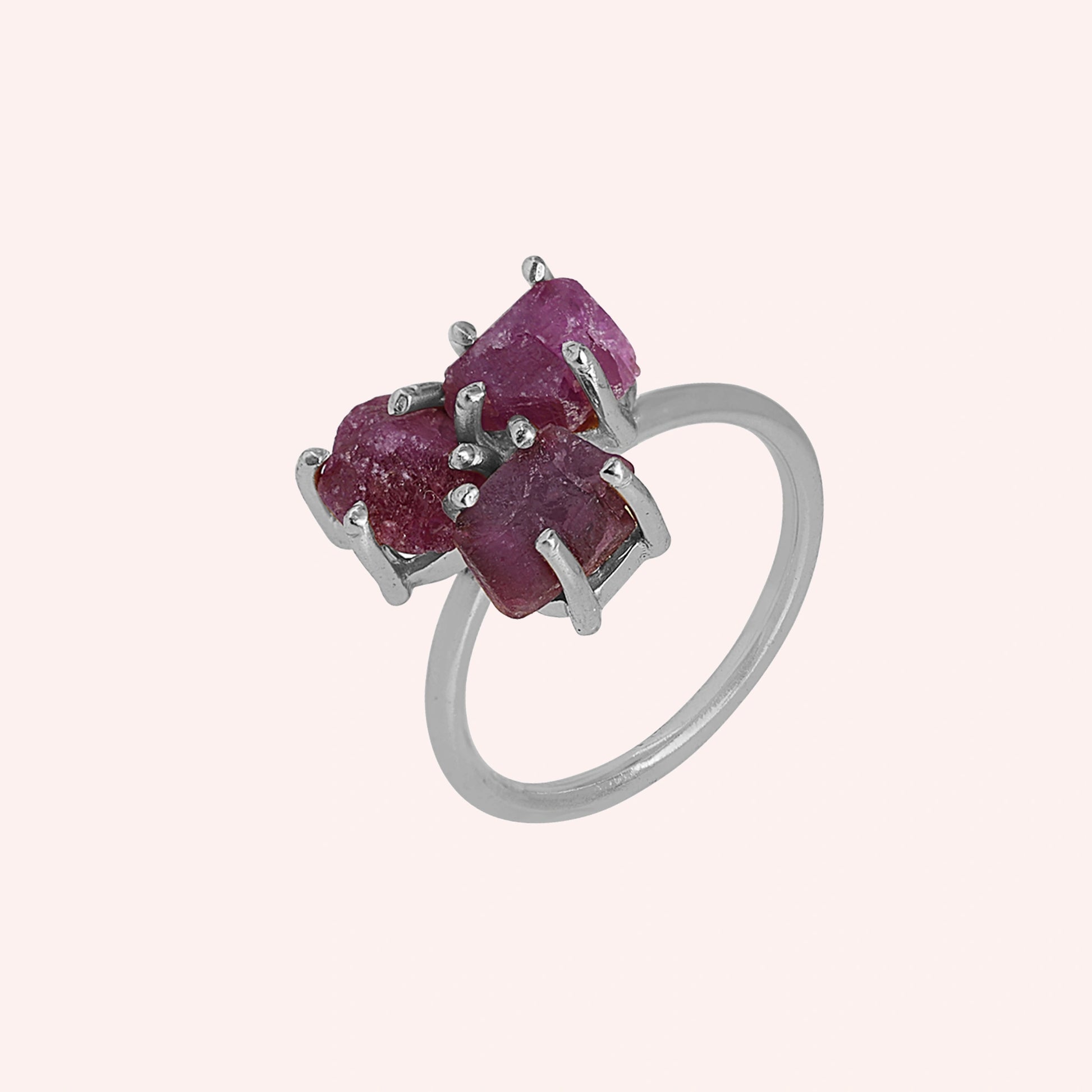Pink_ring_in_sterling_silver_with_raw_tourmaline_stones_at_slight_angle_view_on_solid_pink_background