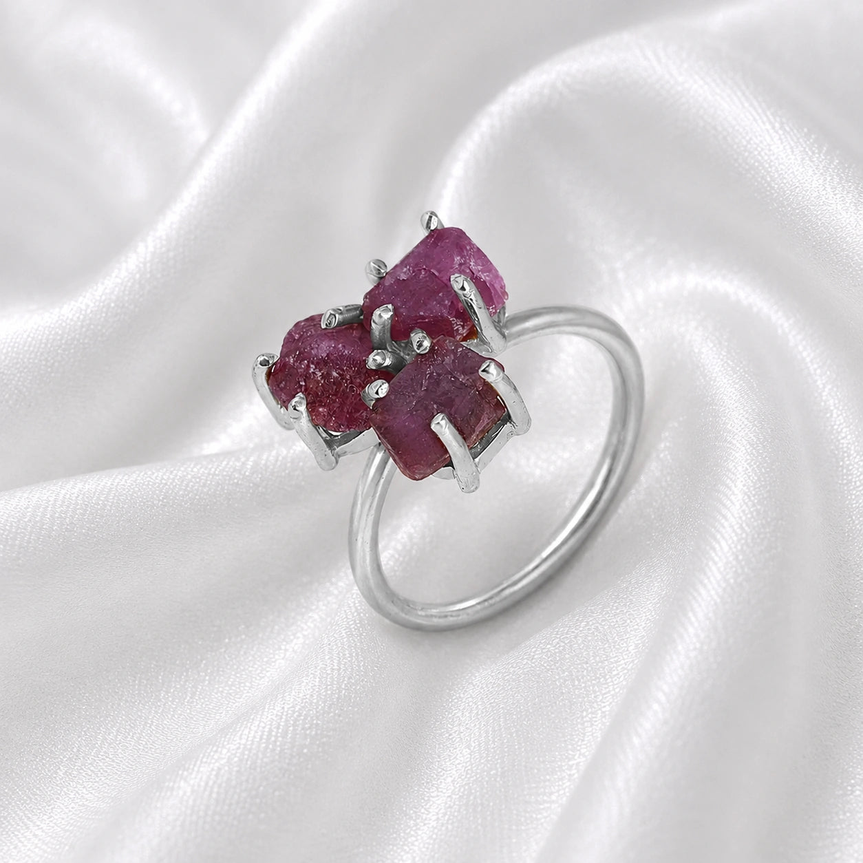 Pink_ring_in_sterling_silver_with_raw_tourmaline_stones_at_slight_angle_view_on_soft_fabric_background