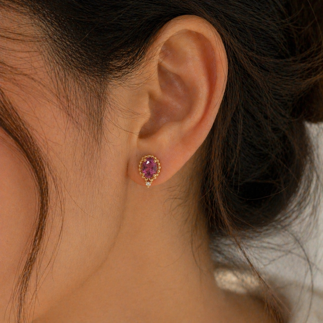 Pink_tourmaline_earrings_in_gold_plated_silver_with_oval_stone_and_a_white_topaz_worn_by_a_model