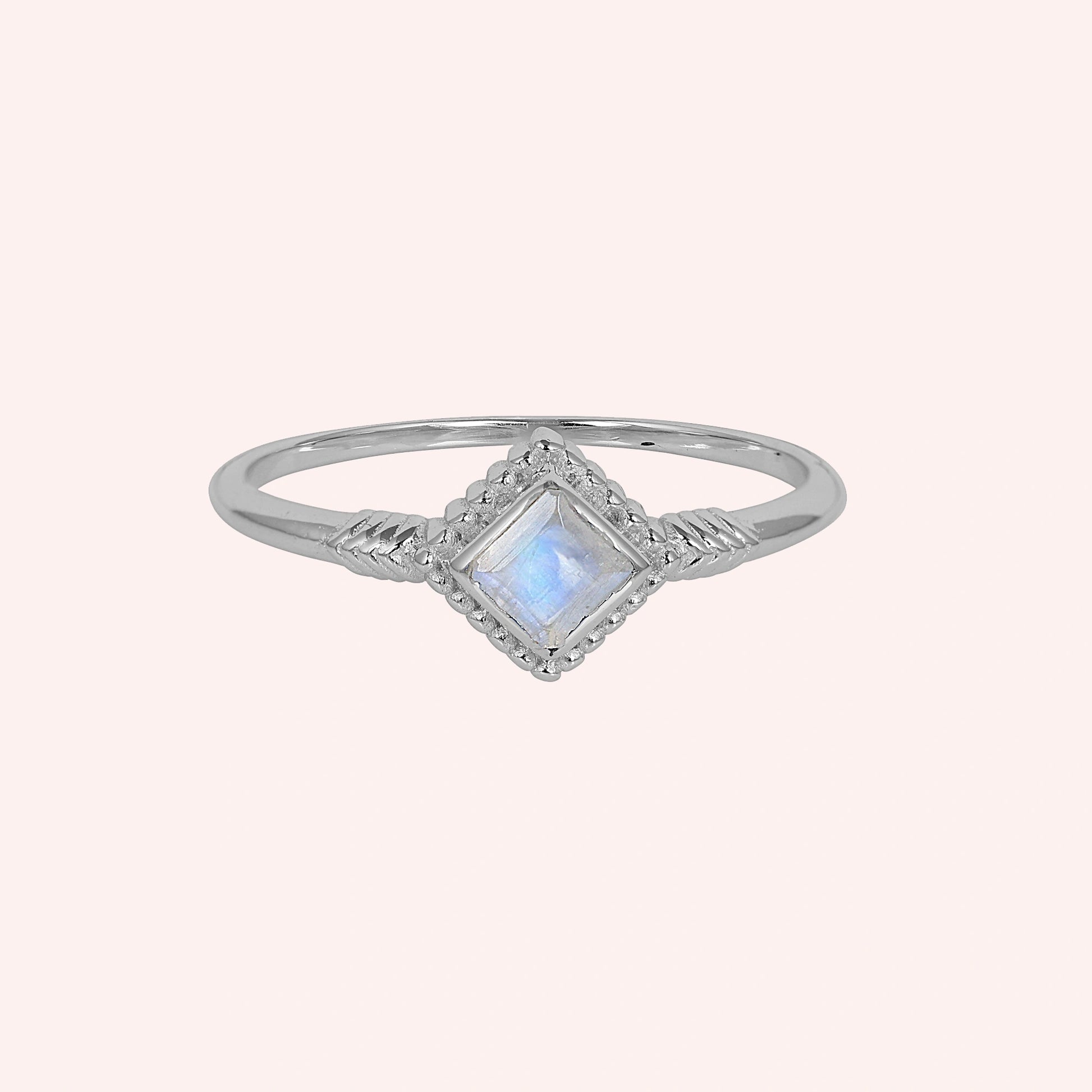 Princess_cut_ring_sterling_silver_with_square_moonstone_and_detailed_band_front_angle_view_on_solid_pink_background