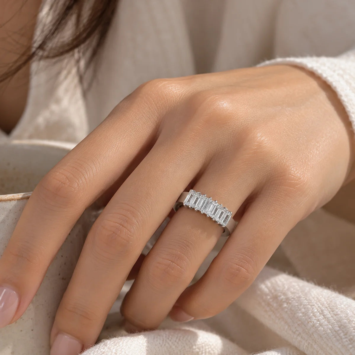 Promise_ring_in_sterling_silver_with_baguette_cut_lab_grown_diamonds_at_front_angle_view_worn_by_a_model