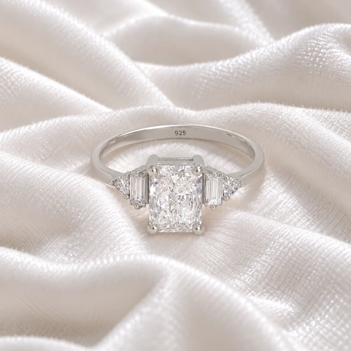 Promise_ring_in_sterling_silver_with_five_CZ_stones_at_front_view_on_soft_fabric_background