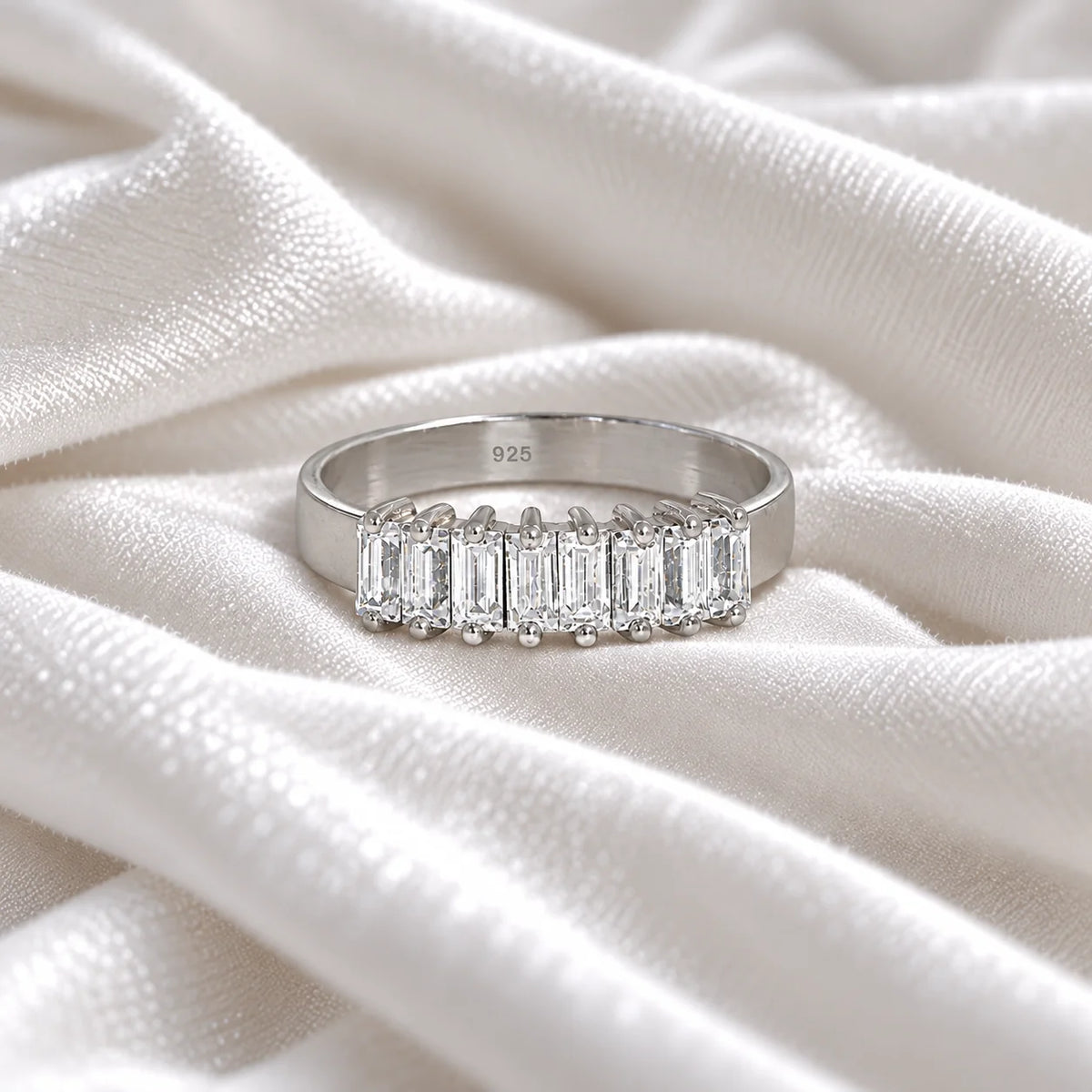 Promise_ring_in_sterling_silver_with_baguette_cut_lab_grown_diamonds_at_front_angle_view_on_soft_fabric_background