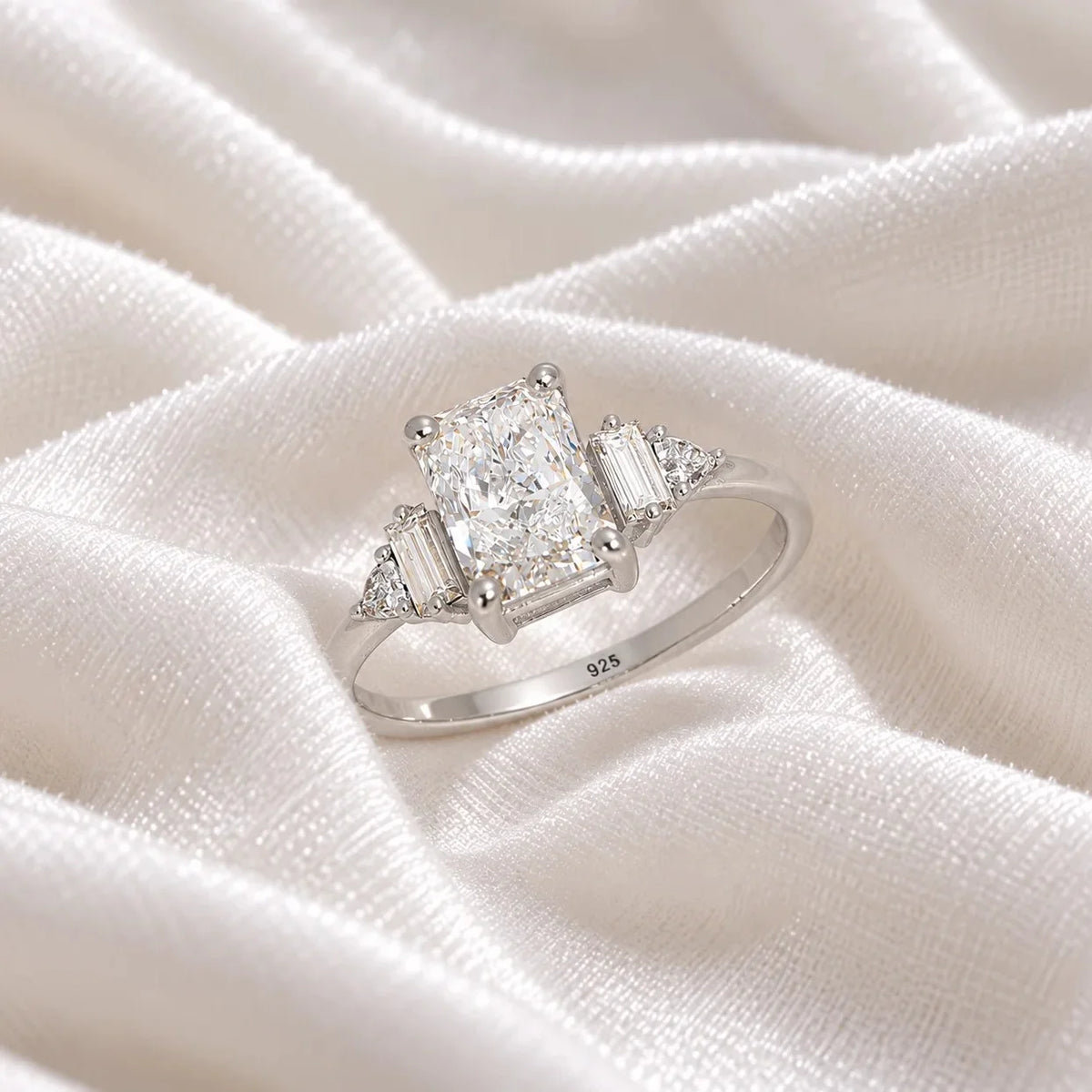 Promise_ring_in_sterling_silver_with_five_CZ_stones_at_side_view_on_soft_fabric_background