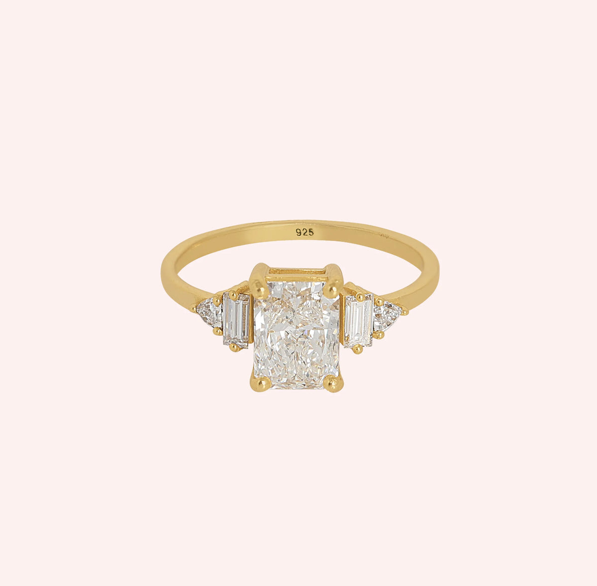 Promise_ring_in_gold_plated_silver_with_five_lab_grown_diamonds_at_front_angled_view_on_solid_pink_background