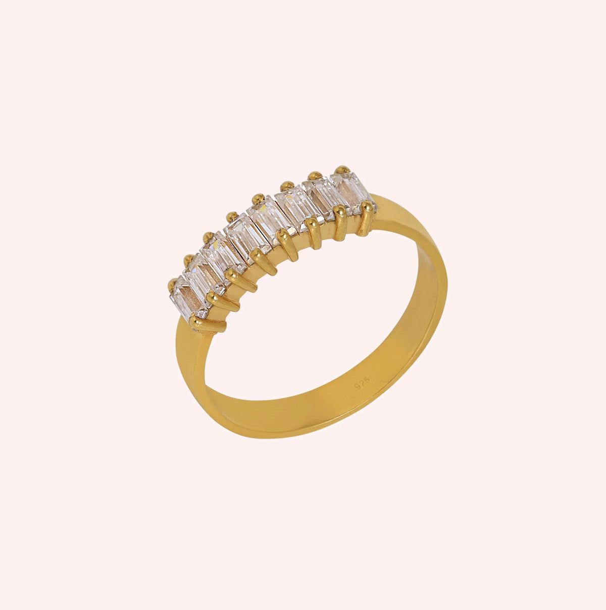 Promise_ring_in_gold_plated_silver_with_baguette_cut_lab_grown_diamonds_at_side_angle_view_on_solid_pink_background