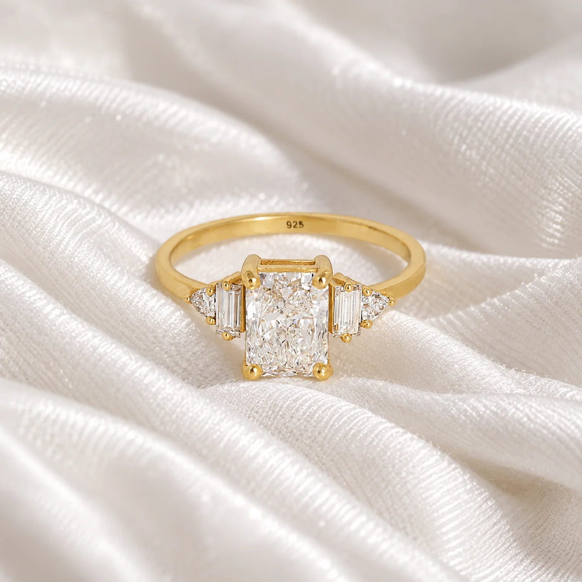 Promise_ring_in_gold_plated_silver_with_five_CZ_stones_at_front_view_on_soft_fabric_background