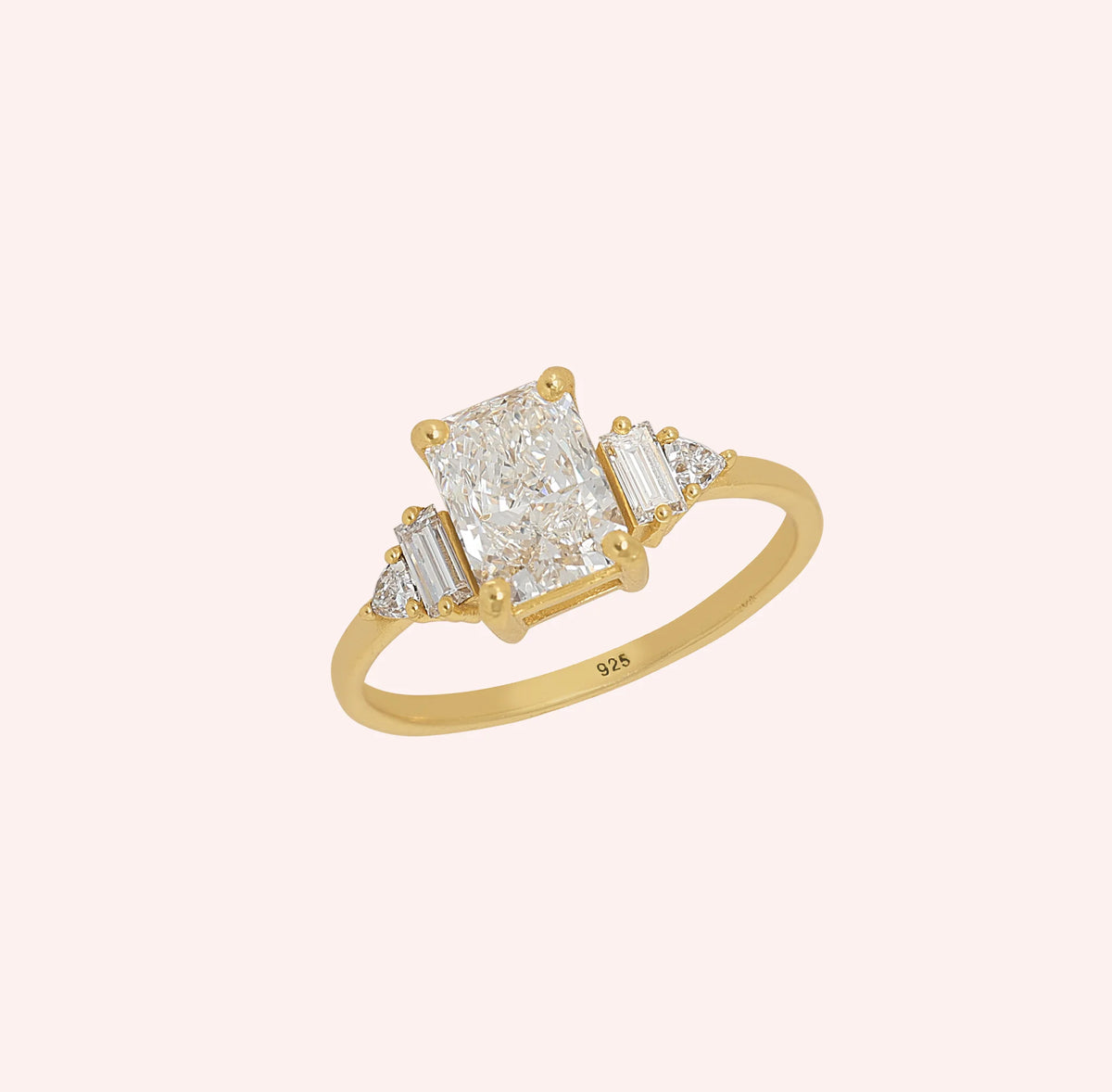 Promise_ring_in_gold_plated_silver_with_five_lab_grown_diamonds_at_slight_angled_view_on_solid_pink_background