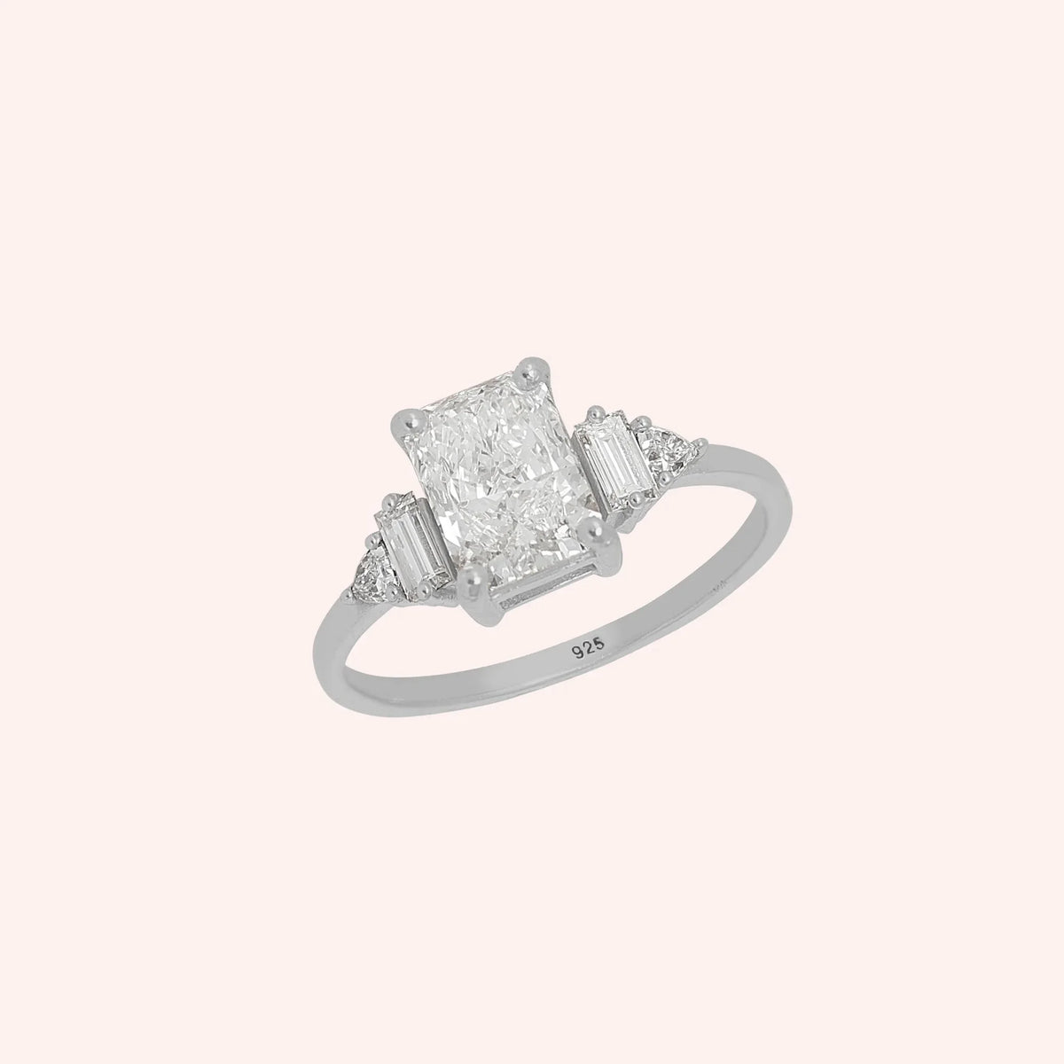 Promise_ring_in_sterling_silver_with_five_CZ_stones_at_side_view_on_solid_pink_background