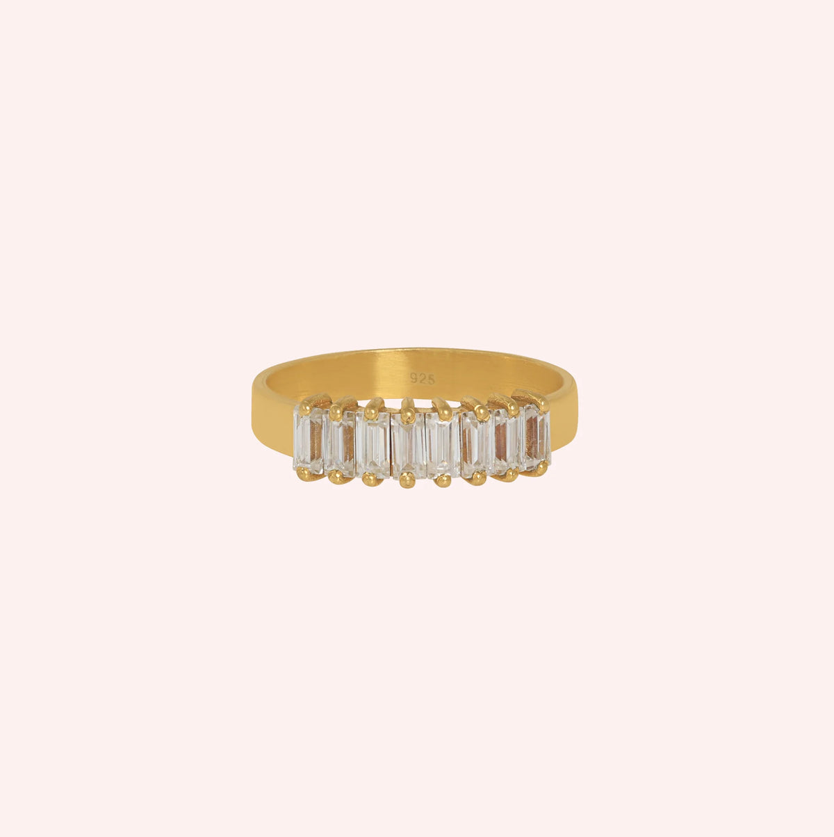 Promise_ring_in_gold_plated_silver_with_baguette_cut_lab_grown_diamonds_at_front_angle_view_on_solid_pink_background