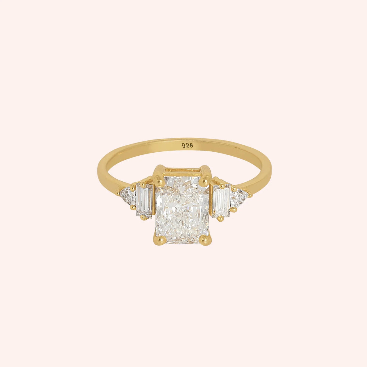 Promise_ring_in_gold_plated_silver_with_five_CZ_stones_at_front_view_on_solid_pink_background
