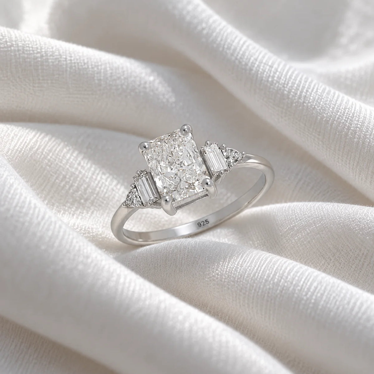 Promise_ring_in_sterling_silver_with_five_lab_grown_diamonds_at_slight_angled_view_on_soft_fabric_background