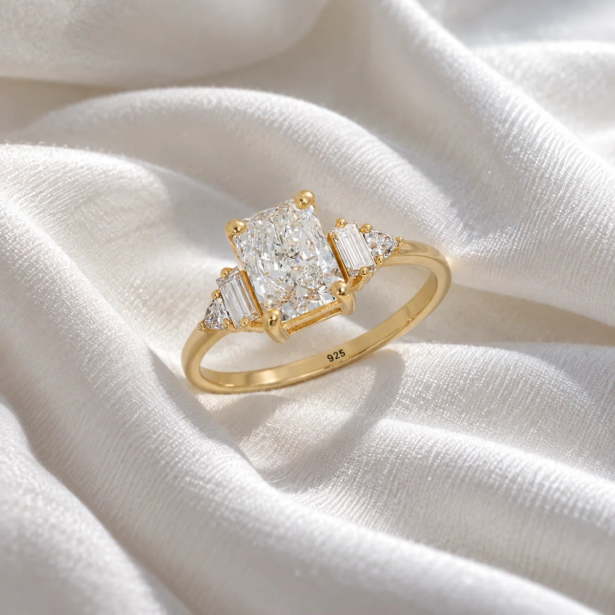 Promise_ring_in_gold_plated_silver_with_five_lab_grown_diamonds_at_slight_angled_view_on_soft_fabric_background