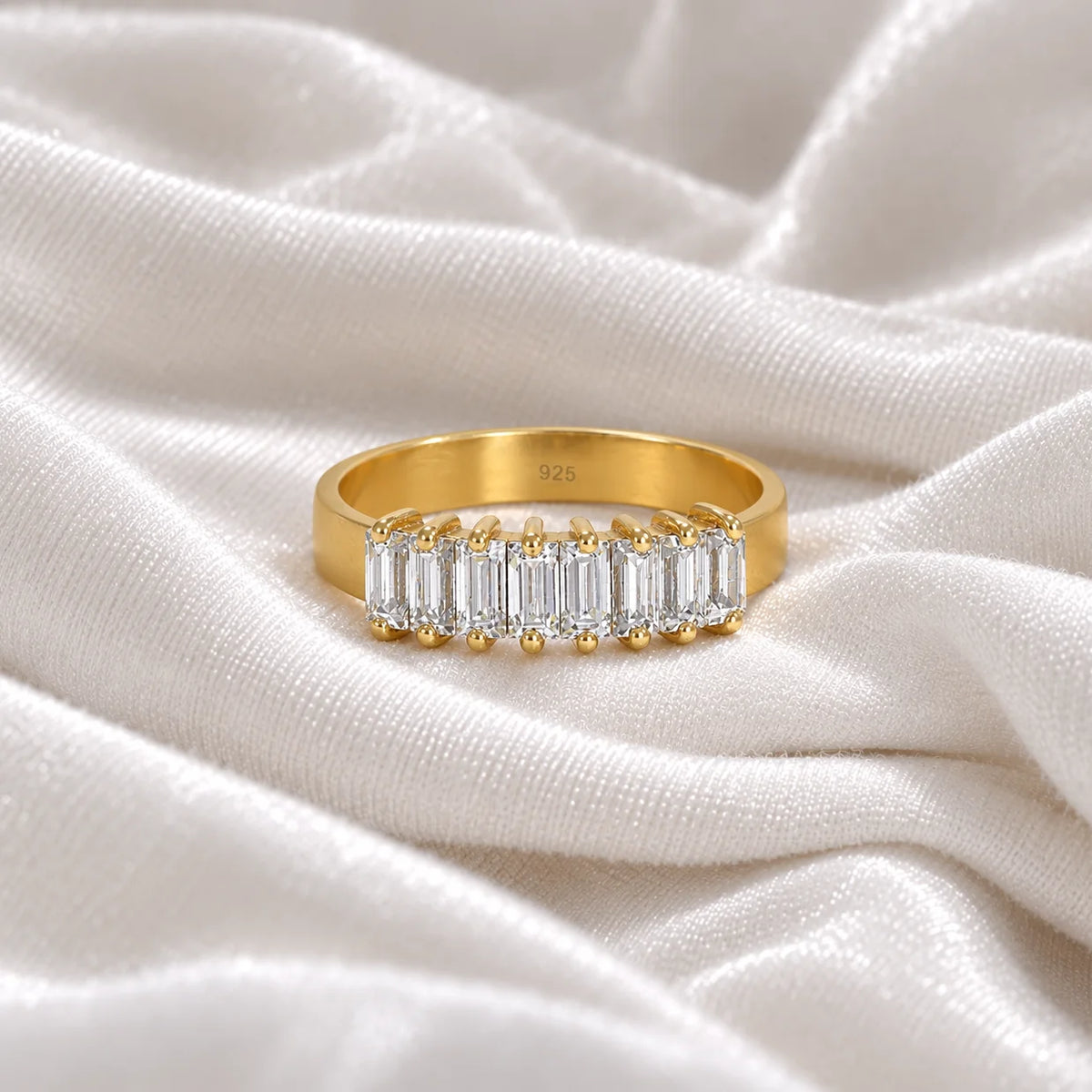 Promise_ring_in_gold_plated_silver_with_baguette_cut_lab_grown_diamonds_at_front_angle_view_on_soft_fabric_background