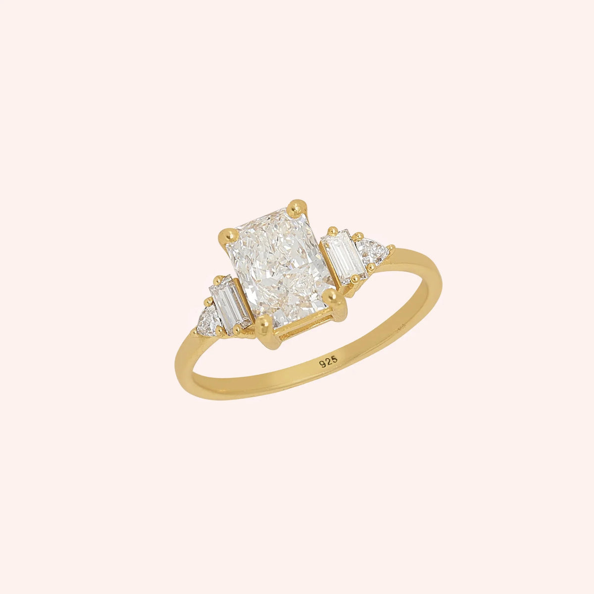 Promise_ring_in_gold_plated_silver_with_five_CZ_stones_at_side_view_on_solid_pink_background