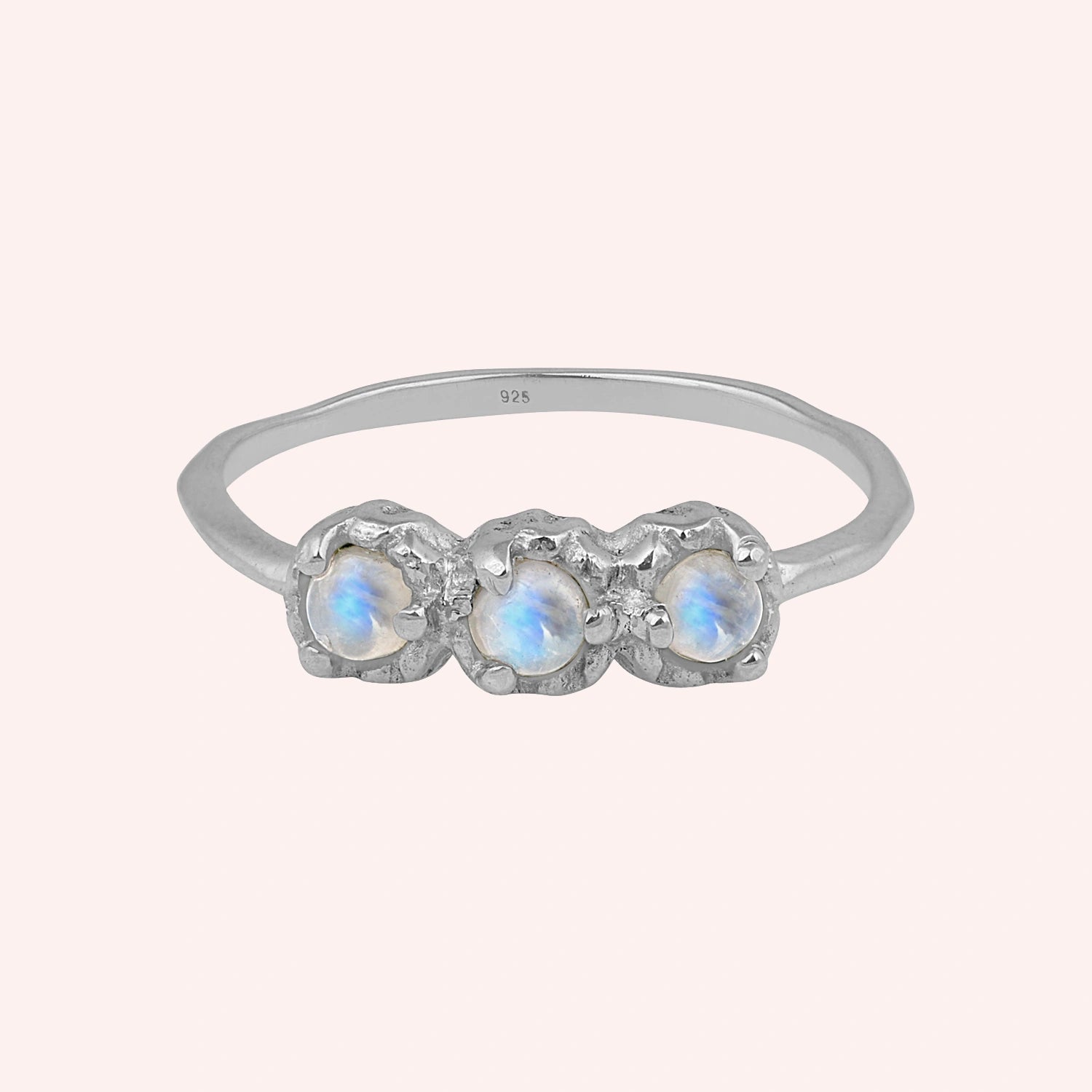Rainbow_moonstone_ring_in_sterling_silver_with_three_moonstones_at_front_angle_on_solid_pink_background