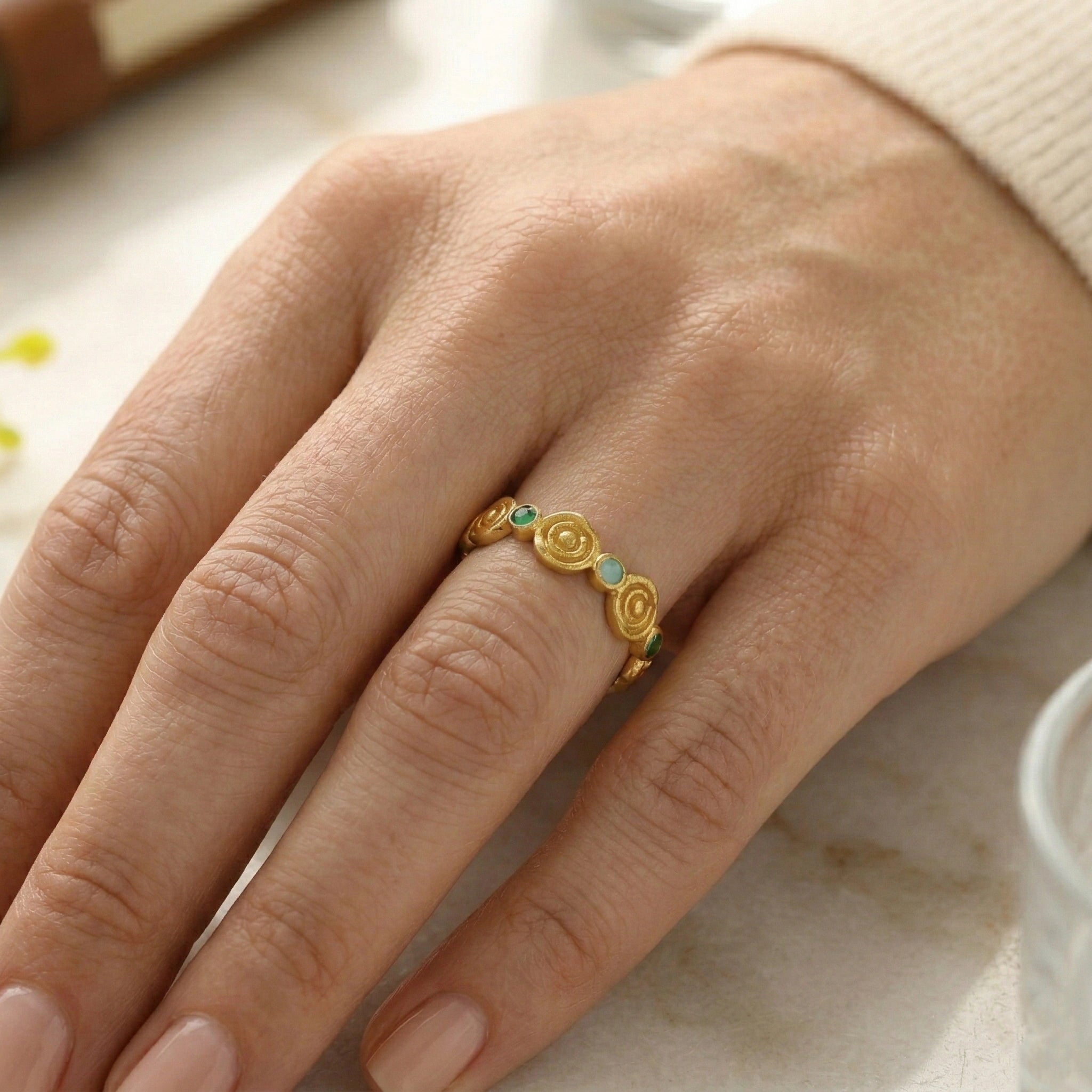 Rose-ring-with-green-and-blue-gemstones-worn-on-hand-fashion-ring-in-natural-light