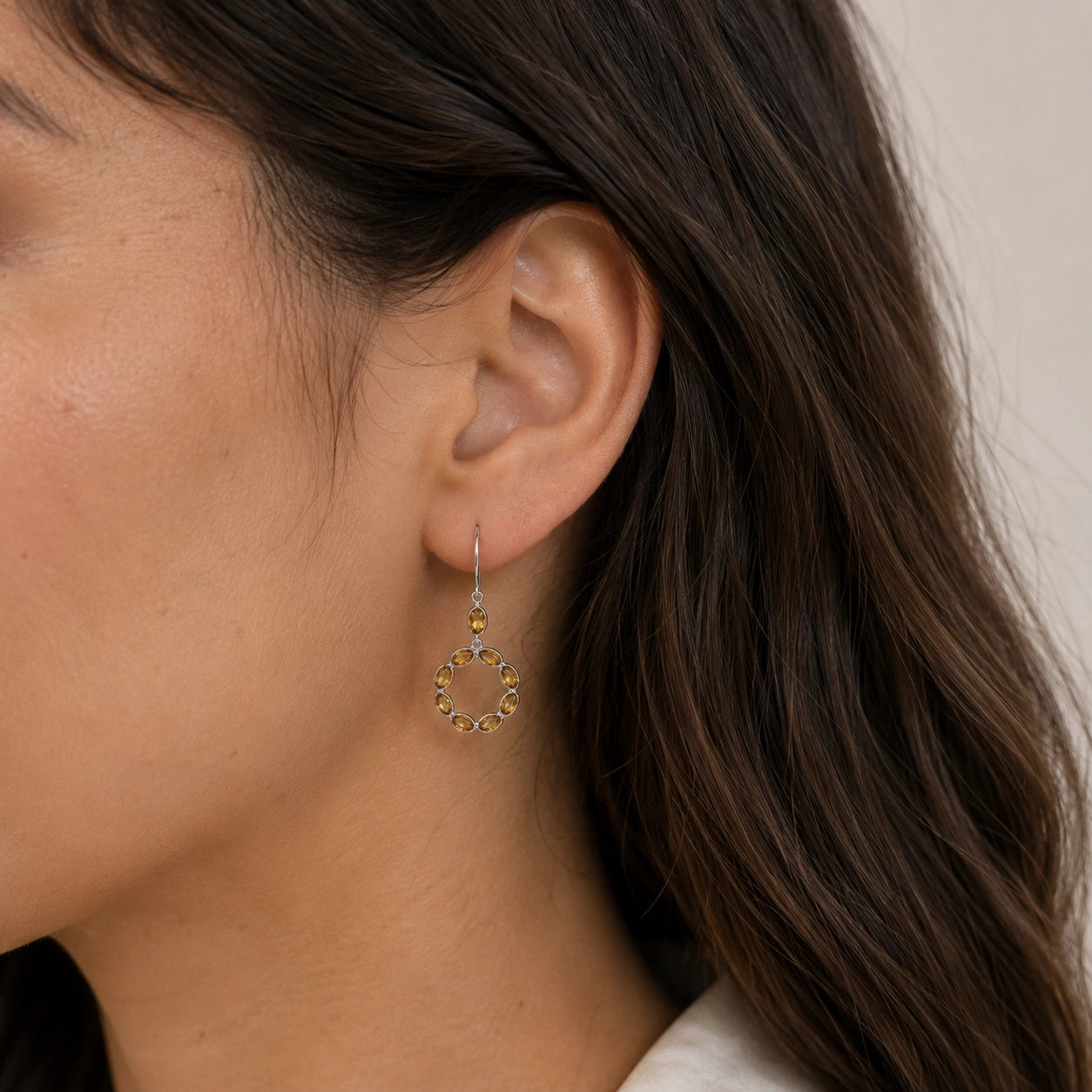 Round_earrings_in_gold_plated_silver_with_oval_citrine_stones_worn_by_a_model