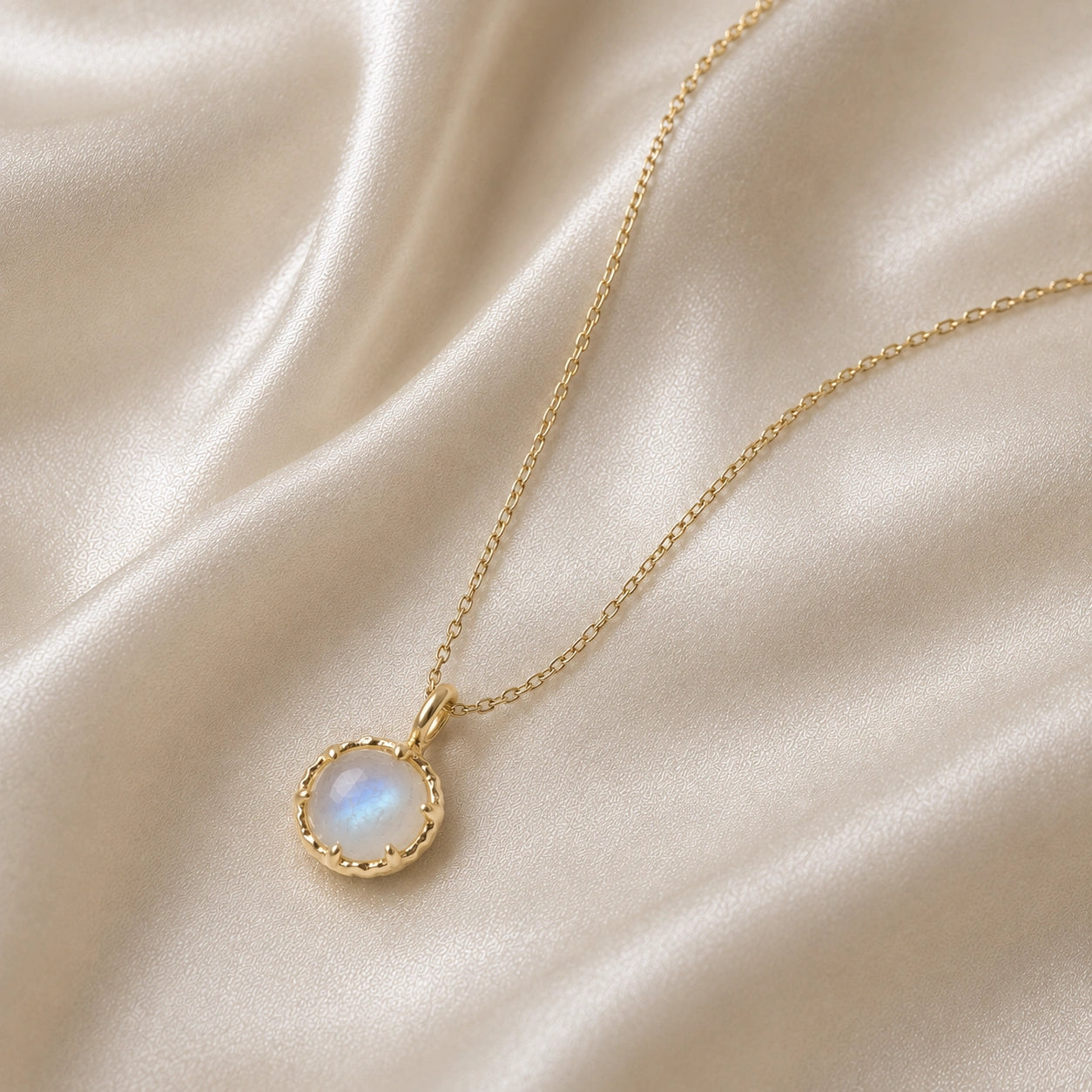 Round_necklace_in_gold_plated_silver_slightly_angled_featuring_round_moonstone_on_a_soft_fabric_background