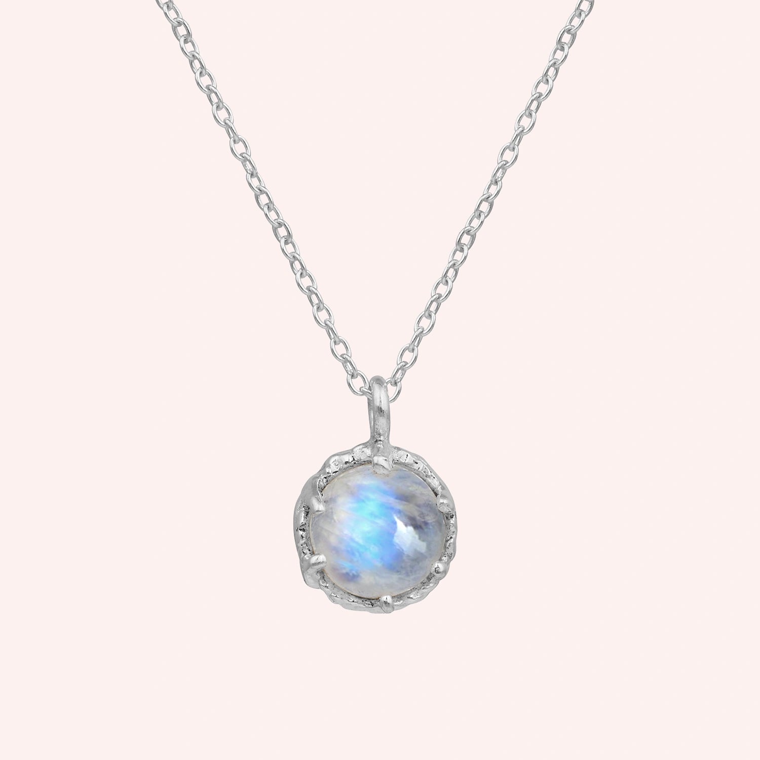 Round_necklace_in_sterling_silver_at_front_angle_featuring_round_moonstone_on_a_solid_pink_background