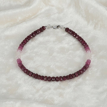 Ruby_bracelet_in_ombre_effect_with_ruby_stones_in_gradient_design_in_front_angle_on_a_white_fabric_background