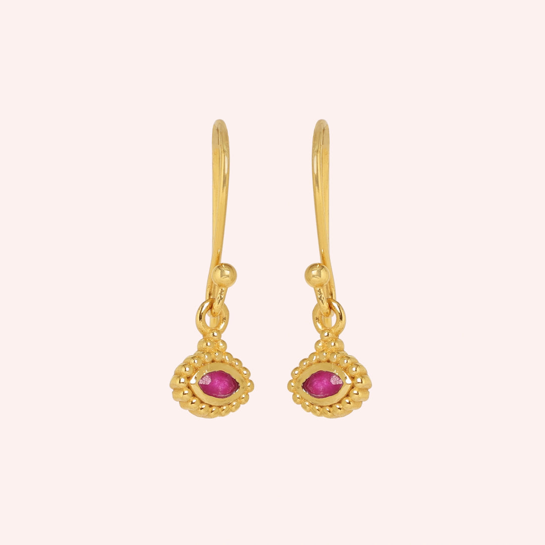 Ruby_earrings_in_gold_plated_silver_with_marquise_ruby_stone_at_front_angle_view_on_solid_pink_background