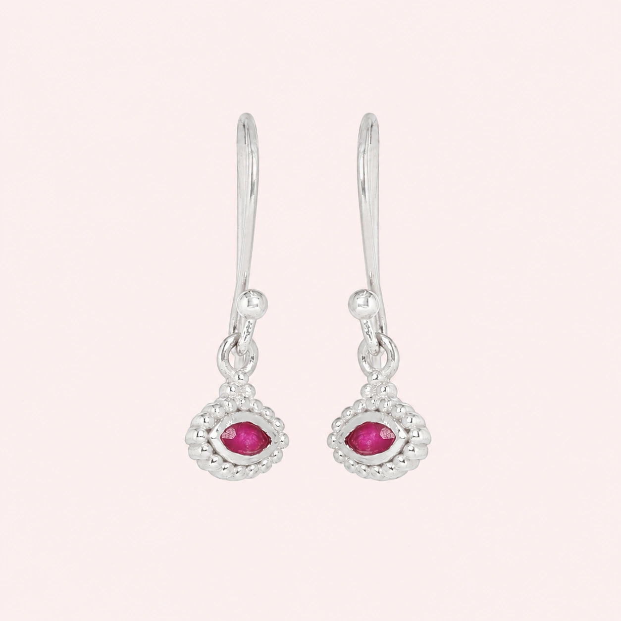 Ruby_earrings_in_sterling_silver_with_marquise_ruby_stone_at_front_angle_view_on_solid_pink_background