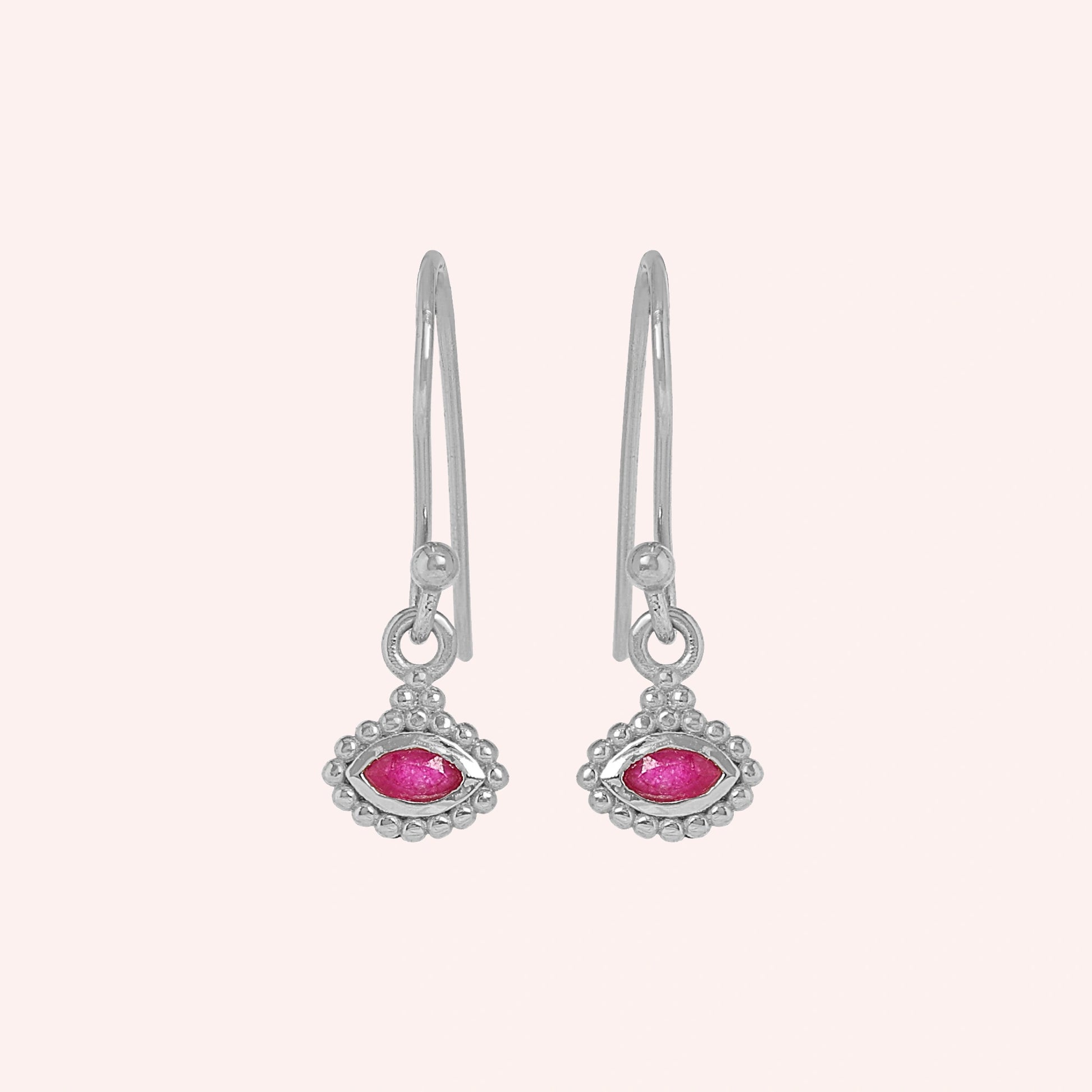 Ruby_earrings_in_sterling_silver_with_marquise_ruby_stone_at_front_angle_view_on_solid_pink_background