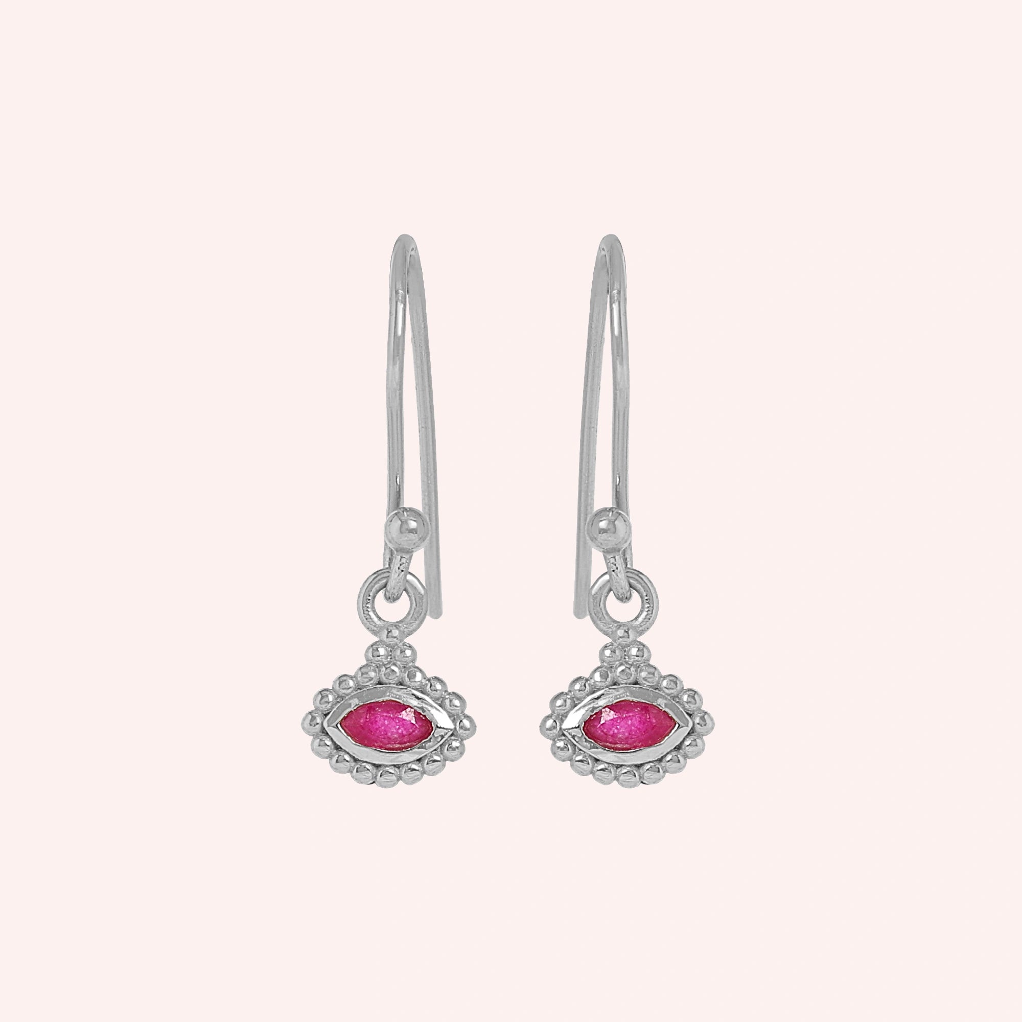 Ruby_earrings_in_sterling_silver_with_marquise_ruby_stone_at_front_angle_view_on_solid_pink_background